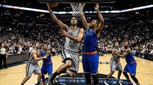 NBA Finals Game 1 action with players battling near the basket in a packed arena.